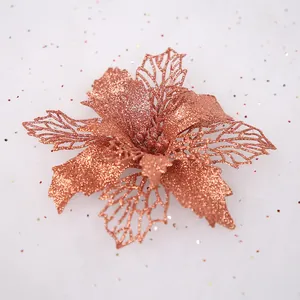 Glittering rose gold cutout artificial poinsettia flower for Christmas tree decoration.