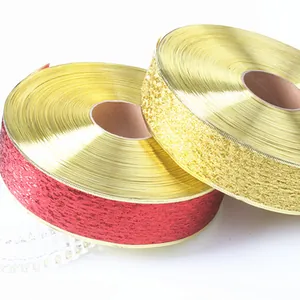 Primer plano de cintas metálicas brillantes rojas y doradas para envolver regalos.