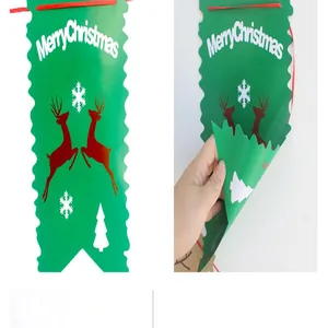 Dettaglio dello striscione natalizio in carta verde con renne e fiocchi di neve