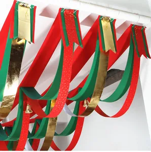 Detail showing hanging red green and gold Christmas wave ribbons with small bells