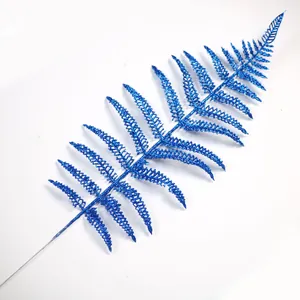 Primo piano di un ramo di foglia di felce blu glitterata per decorazione albero di Natale.