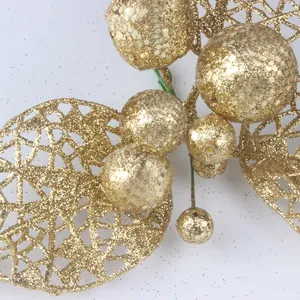 Nahaufnahme goldener Weihnachtsdekoration mit Glitzerblättern und Beeren für Kränze.