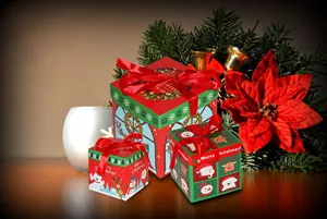 Juego de 3 cajas de regalo navideñas festivas con estampado y lazos rojos.