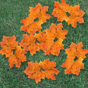 Bovenaanzicht van realistische oranje kunstmatige esdoornbladeren op groen gras