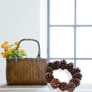 Close-up of a natural pinecone Christmas wreath next to a rustic woven bamboo basket.