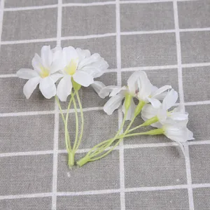 Detailweergave van kleine witte kunstbloemen met geel hart voor al uw DIY-decoraties