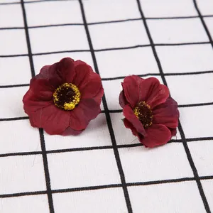Gedetailleerde weergave van twee donkerrode kunstmatige zijden bloemhoofdjes voor knutselen