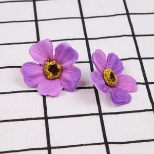 Gedetailleerde macro-opname van twee paarse kunstzijden bloemhoofdjes voor knutselen.