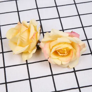 Detailweergave van twee kunstmatige gele rozenkoppen met roze randen voor doe-het-zelf decoratie