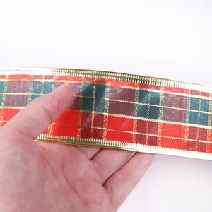 Détail macro d'un ruban de Noël à carreaux écossais rouge et vert avec bords dorés