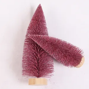 Detailansicht von rosaroten Mini-Weihnachtsbäumen mit weißem Glitzer und Holzsockel.