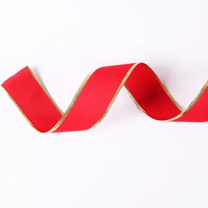 Close-up of red velvet ribbon with shimmering gold-wired edges for Christmas decor