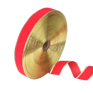 Red velvet ribbon with gold edges unrolled for Christmas tree decoration detail