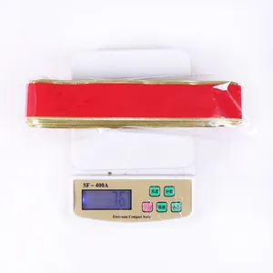 Weight measurement of red velvet ribbon with gold edges on electronic scale for decor