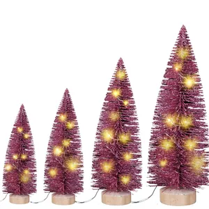 Vier magentarote Mini-Weihnachtsbäume mit LED-Lichtern und Holzsockeln als Tischdeko