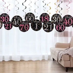 Close-up of black spiral hanging decorations with glittery pink and silver age number cards