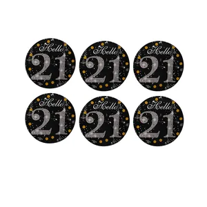 Close-up of circular black party tags featuring silver Hello 21 text and gold dots