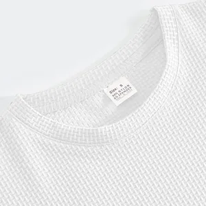 Close-up of white bubble gauze men's t-shirt showing collar tag and fabric texture