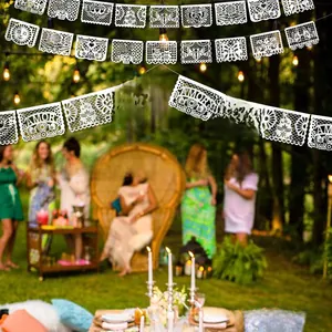 White Mexican papel picado banner with intricate cutouts for outdoor garden party decoration
