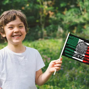 Bambino sorridente tiene una bandiera messicana in poliestere 14x21cm all'aperto