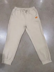 Detailed view of men's beige joggers featuring a unique textured jacquard pattern.