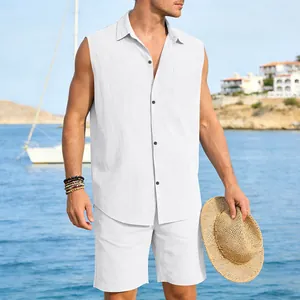 Male model wearing white sleeveless linen shirt and shorts in a sunny coastal setting