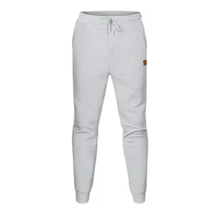 Λεπτομερής άποψη του γκρι ανδρικού joggers με ανάγλυφο σχέδιο ζακάρ και μανσέτες.