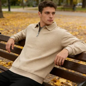 Detailed view of men's beige quarter-zip sweatshirt with geometric jacquard texture.