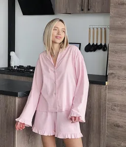 Détail de l'ensemble de pyjama rose avec des volants délicats et une texture douce.