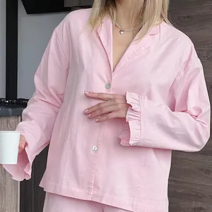 Ensemble de pyjama rose élégant à manches longues avec poignets à volants et boutons.