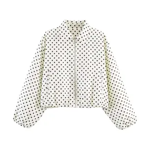 Detail view of a white retro short jacket with black polka dots and zipper closure