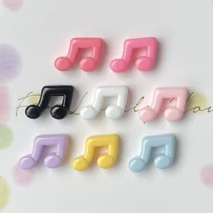 Close-up view of various colorful glossy mini music note resin charms for DIY phone case crafts