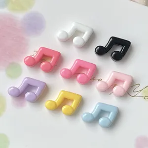 Detailed view of colorful glossy resin musical note charms for DIY cream glue accessories.