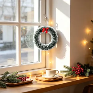 Christmas bow wreath with white and green tinsel hanging on a bright sunny window