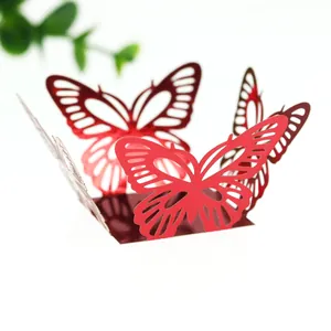 Vue détaillée en gros plan d'une boîte à bonbons papillon ajourée rouge pour mariage