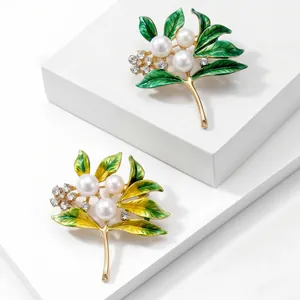Detailed view of two elegant leaf brooches with pearls and rhinestones