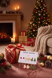 Festive Christmas earring set displayed on a white card in a cozy room setting.
