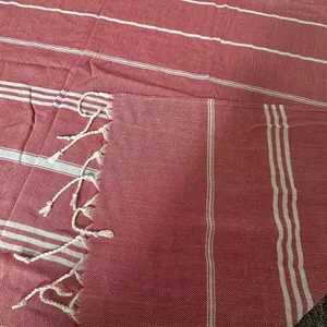Close-up of red and white striped Turkish beach towel with handmade white tassels