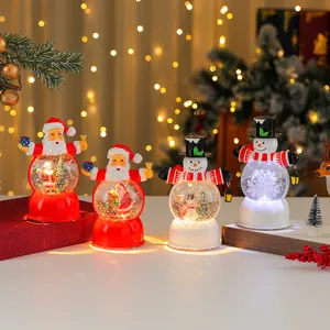 Detailed view of festive Christmas Santa and Snowman light-up musical snow globes
