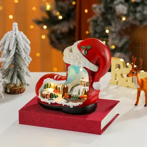 Detail showing miniature village with LED lights inside resin Santa boot music box
