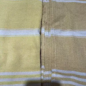 Macro detail of yellow and white striped woven fabric of a Turkish beach towel