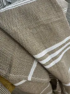 Detailed close-up of a Turkish beach towel showing woven brown texture and white stripes