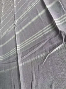 Macro view of light purple Turkish beach towel with white stripes and fine woven texture