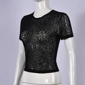 Dettaglio di una t-shirt in rete trasparente nera con stampa leopardata floccata su manichino.