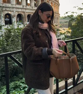 Loose brown sherpa teddy coat styled with a pink scarf and tan tote bag in Rome