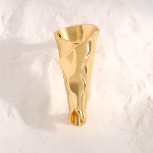 Detailansicht einer goldfarbenen Blumenstrauß-Brosche mit einer künstlerischen Textur.