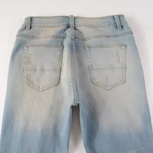 Detailed view of back pockets and light blue wash on men's slim fit distressed denim jeans