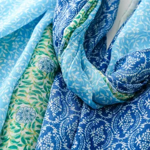 Texture détaillée d'un foulard léger avec des motifs floraux bleus et verts d'été
