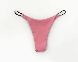 Macro view of pink low-waist cotton T-back thong with black double thin straps.