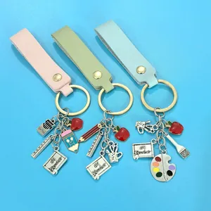 Creative teacher appreciation keychain with apple pencil and palette school charms.